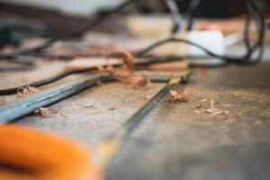 Home A messy workshop tabletop with tools and wood shavings, highlighting craftsmanship.